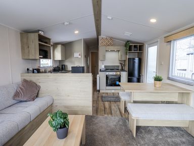 A living room with a sofa and dining area at Hadrian's Rest in Wigton