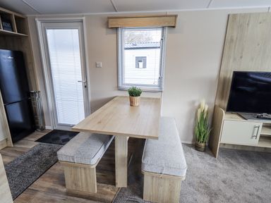 A dining area with a table and benches at Hadrian's Rest in Wigton