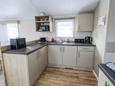 A kitchen with cabinets and appliances at Hadrian's Rest in Wigton