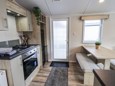A kitchen with a stove and a table at Hadrian's Rest in Wigton