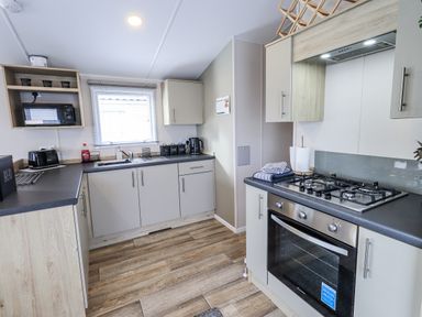 A kitchen with cabinets and appliances at Hadrian's Rest in Wigton