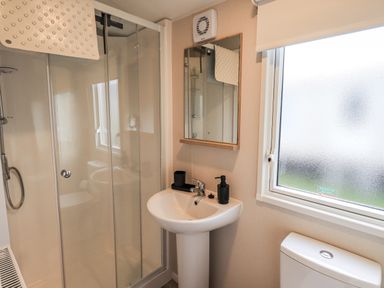 A bathroom with a shower, washbasin, and toilet at Hadrian's Rest in Wigton