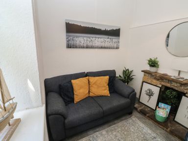 A living room with a sofa and wall art at The Cottage in Budleigh Salterton