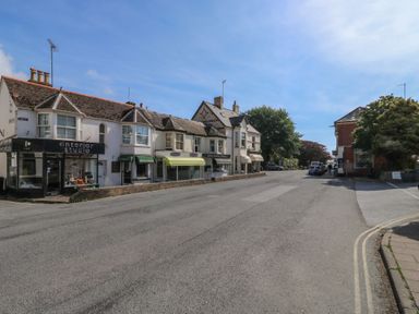 A street view with shops and vehicles at The Cottage in Budleigh Salterton