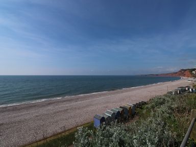 A beach with pebbles and beach huts at The Cottage in Budleigh Salterton
