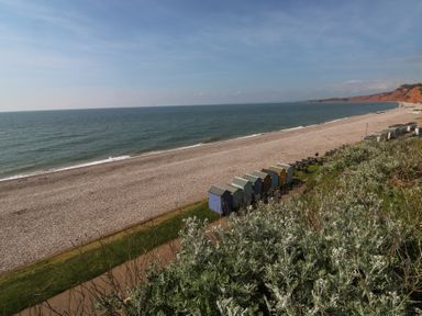 A beach with huts and a sea view at The Cottage Budleigh Salterton