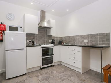A kitchen with appliances and cabinets at Castle Rag in Lydney