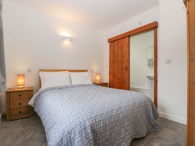 A bedroom with a bed and bedside tables at Castle Rag in Lydney