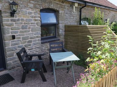 An outdoor seating area with chairs and a table at Castle Rag in Parkend