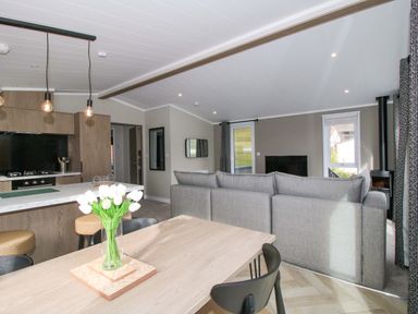 A living room with a sofa and dining area at Tulip in Eardisland