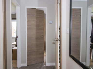 A corridor with a door and mirror at Tulip in Eardisland