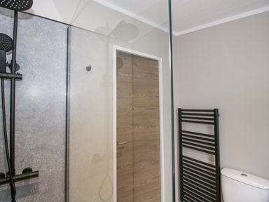 A bathroom featuring a shower, toilet, and heated towel rail at Tulip in Eardisland