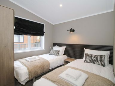 A bedroom with two beds and a window at Poppy in Eardisland