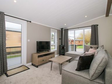 A living room with a television and a coffee table at Poppy in Eardisland