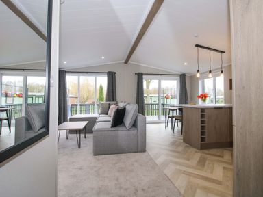 A living room with a sofa and dining area at Poppy Eardisland