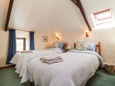 A bedroom with two beds and curtains at Applestore in Wadebridge