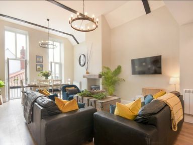 A living room with a sofa and television at Juniper Cottage in 