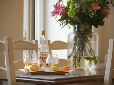 A dining room table with food and drinks at Juniper Cottage