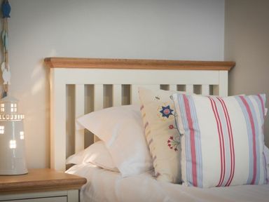 A bed with pillows and a lamp at Juniper Cottage