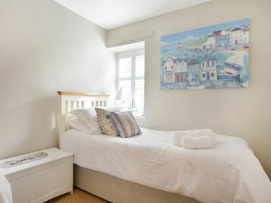 A bedroom with two beds and wall art at Juniper Cottage