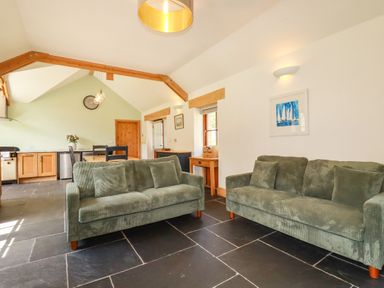 A living room with two sofas and a table at Little Trethellan in Trethellan near Lanner