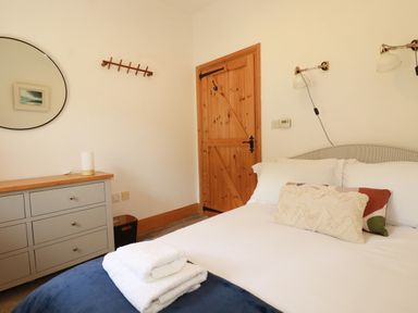 A bedroom with a bed and dresser at Little Trethellan in Trethellan near Lanner