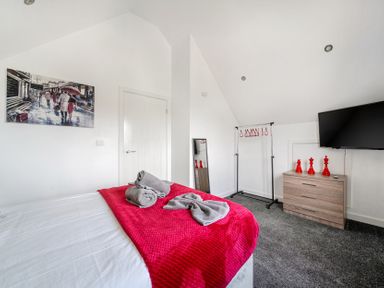 A bedroom with a bed, television, and dresser at Ruby Red near Brigg