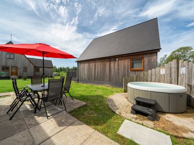 An outdoor area with a table and chairs under an umbrella at Ruby Red near Brigg
