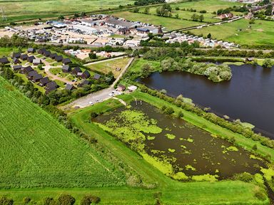 An aerial view of residential homes and a lake at Ruby Red near Brigg