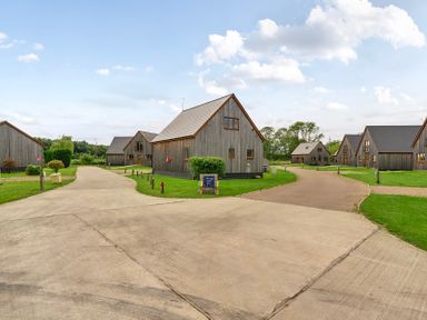 An outdoor area with wooden cabins and a path at Pumpkin Lodge near Brigg