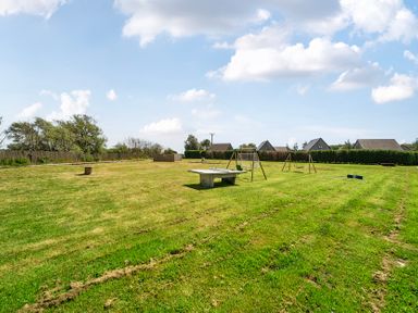An outdoor area with swings and a picnic table at Pumpkin Lodge near Brigg