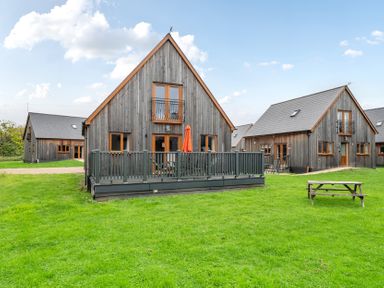 A view of several houses with a deck and grass area at Lodge 25 - Pumpkin Near Brigg