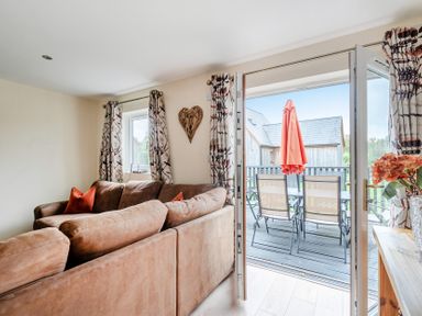 A living room with a sofa and balcony access at Lodge 25 - Pumpkin near Brigg