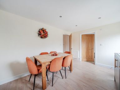 A dining room with a table and orange chairs at Lodge 25 - Pumpkin near Brigg