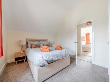 A bedroom with a bed and towels on top at Lodge 25 - Pumpkin Near Brigg