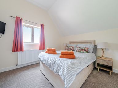 A bedroom with a bed and curtains at Lodge 25 - Pumpkin near Brigg