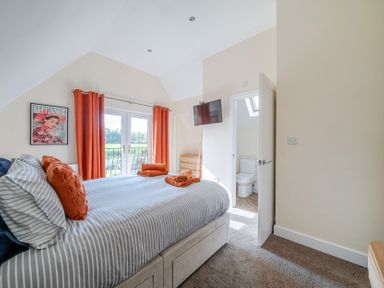 A bedroom with a bed and television at Lodge 25 - Pumpkin near Brigg