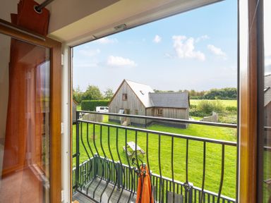 View from a balcony overlooking a house and green area at Lodge 25 - Pumpkin near Brigg