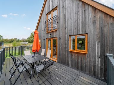 An outdoor patio with a table and chairs at Lodge 25 - Pumpkin Near Brigg