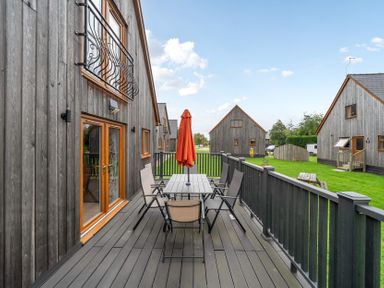 An outdoor area with a table and chairs under an umbrella at Lodge 25 - Pumpkin near Brigg