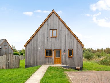 A wooden house facade with doors and windows at Lodge 25 - Pumpkin near Brigg
