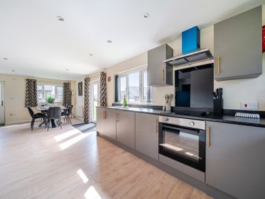 A kitchen with cabinets and a dining area at Poker Lodge Near Brigg