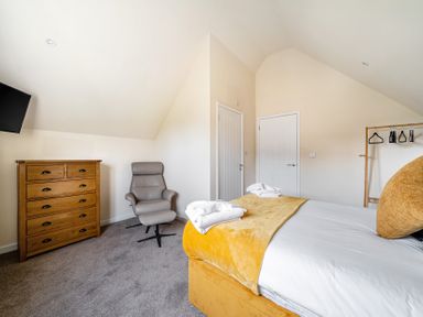 A bedroom with a bed and dresser at Poker Lodge near Brigg