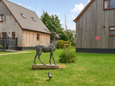 A garden with a deer statue and houses at Poker Lodge near Brigg
