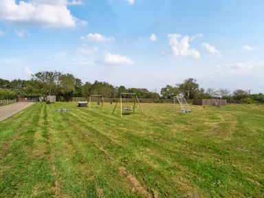 A garden with swings and a play area at Poker Lodge near Brigg