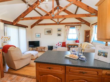 A living room with a television and furniture at Casa Mia in Goodwick