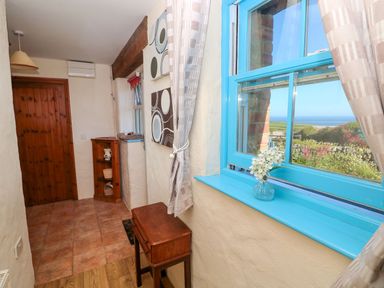 A hallway with a table and a window at Casa Mia in Goodwick