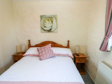 A bedroom with a bed and bedside tables at Casa Mia Goodwick