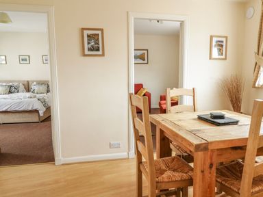 A dining room with a wooden table and chairs at Cottage No 9 in Keswick