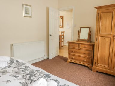 A bedroom with a bed and a wardrobe at Cottage No 9 in Keswick